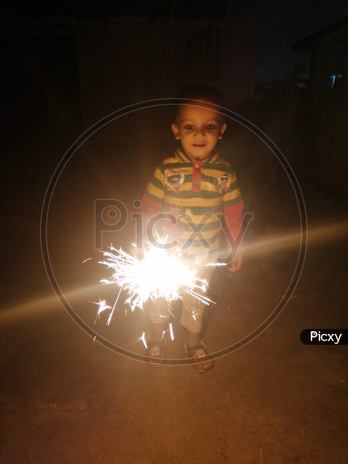 A little kid playing with sparkler