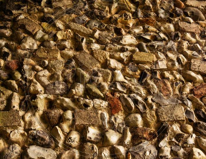 Close Up Of Textured Surface Of Ancient Ruins. Old English Flint Stone Weathered By The Centuries