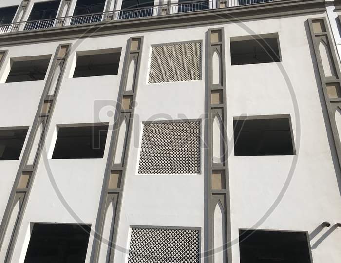 An Elevated Car Parking Of High Rise Building With Aluminum Windows Framed With Black Tinted Sun Protection Film For The Privacy Purposes