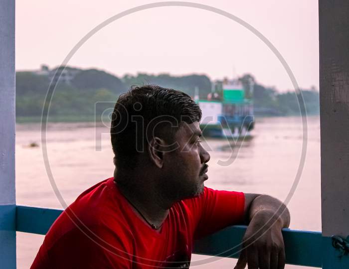 Man Looking At The Beautiful Sunset While Traveling Through A Ferry Ride