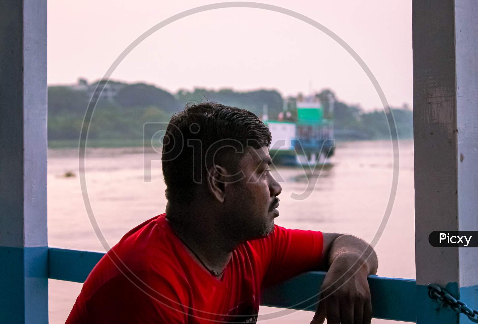 Man Looking At The Beautiful Sunset While Traveling Through A Ferry Ride