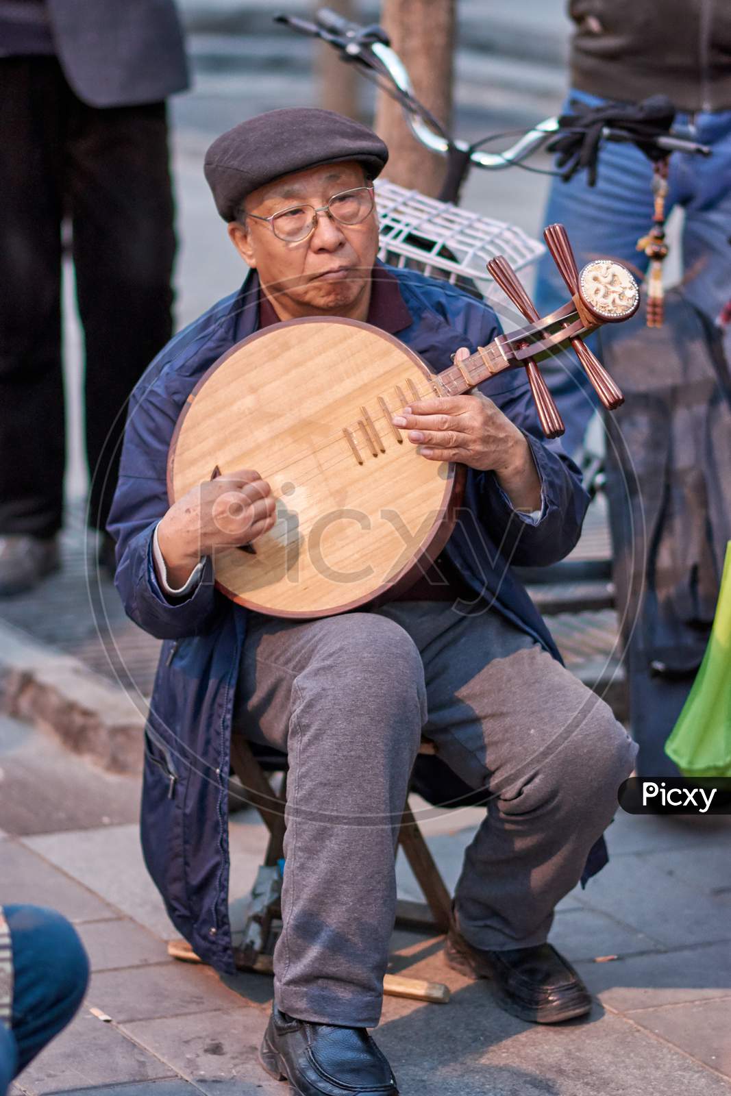 Elderly Man Playing Traditional Chinese Instrument In A Park In Beijing, China