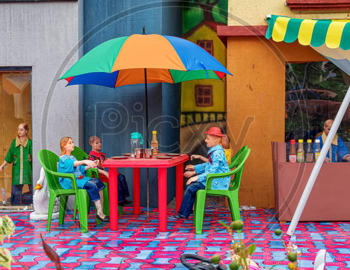 Kolkata, India. A Creation Inspired By Gulliver'S Travels By Jonathan Swift.Funny Picture Of A Lilliput Toys Is Sitting At A Coffee Table In Yard. October 2019
