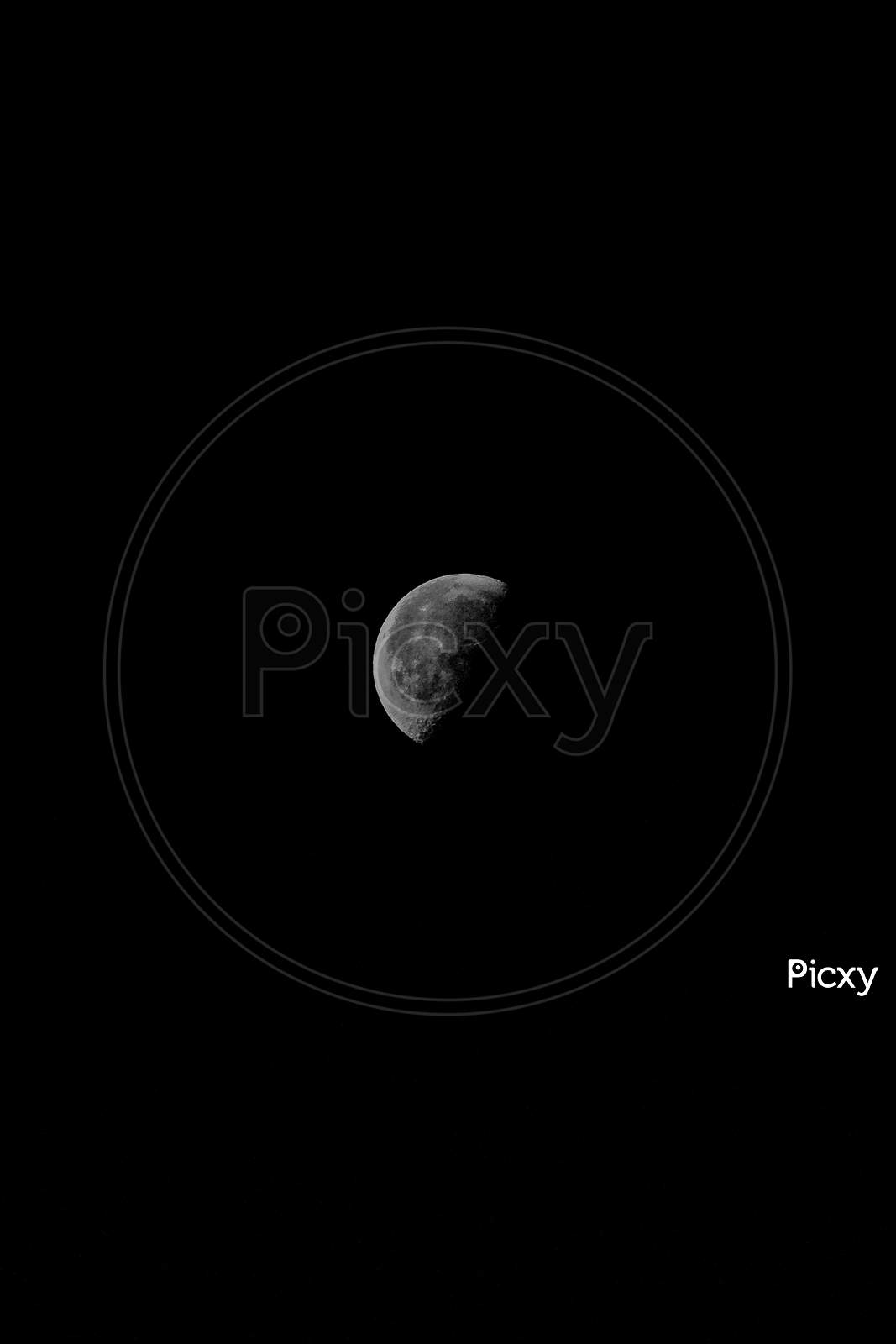A Close Up Of A Dark Grey Moon Over A Full Black Background