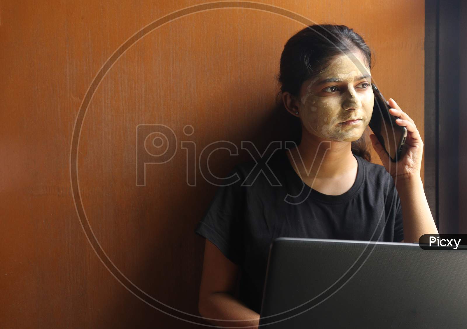 women working on laptop and applying face pack