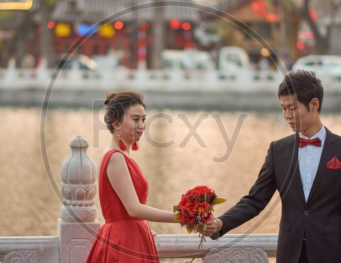 Cute Chinese Wedding Couple Posing Outdoors In Houhai Lake Park, Beijing, China
