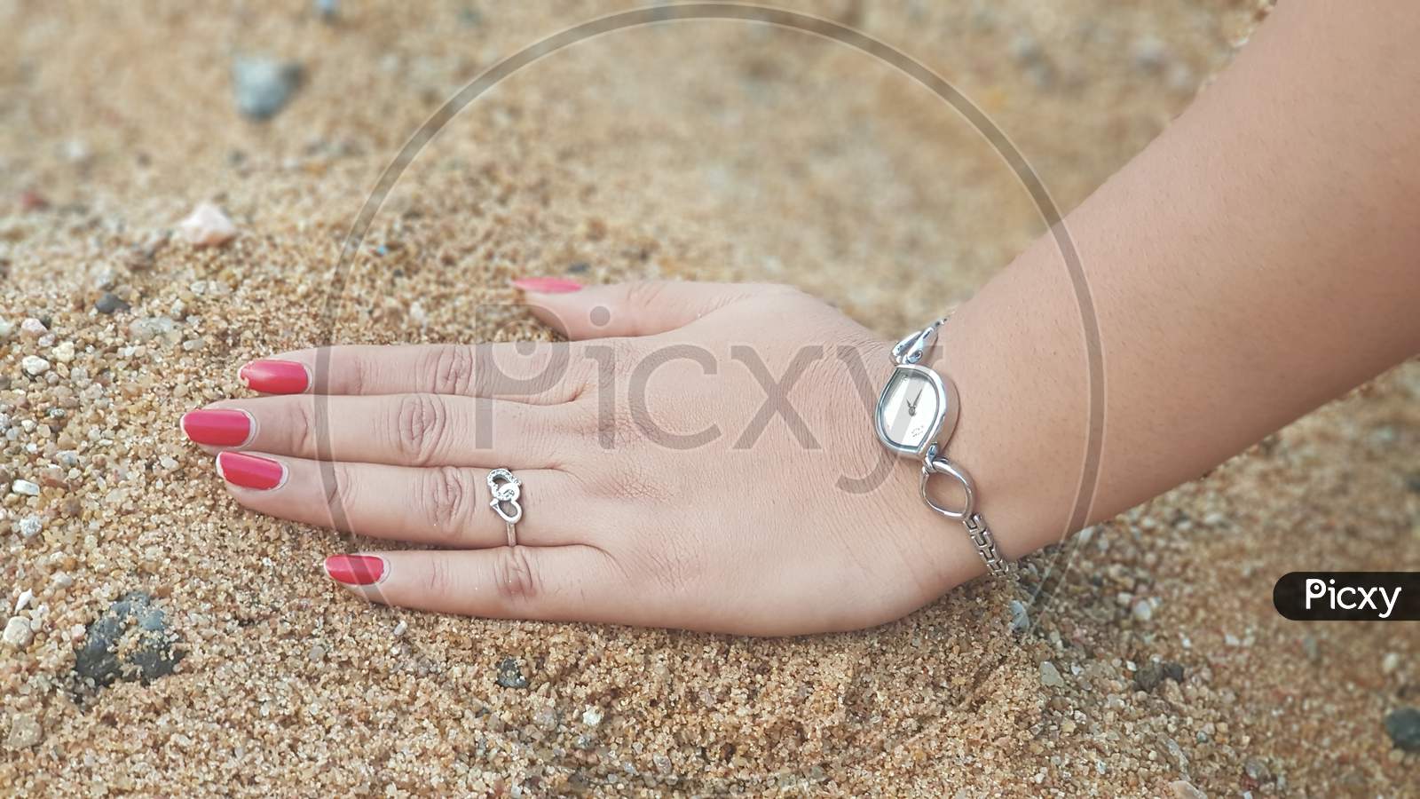 Female hand five fingers isolated on sand background