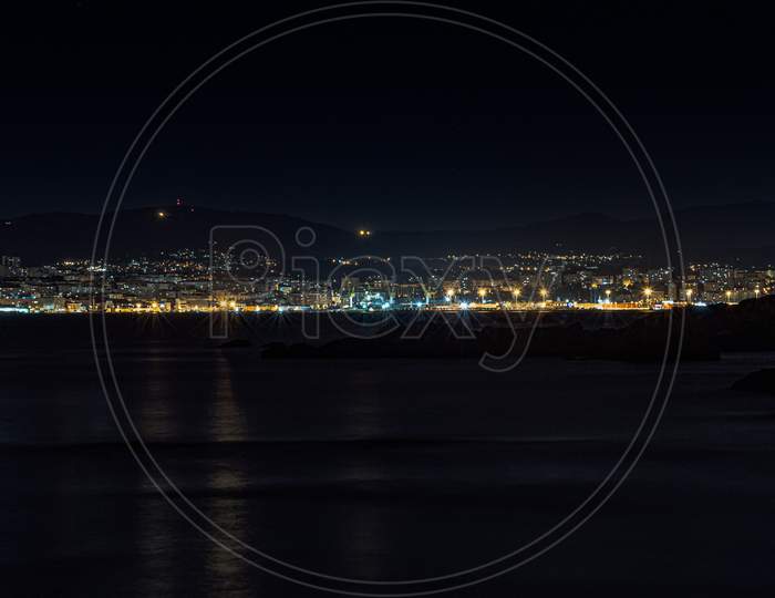 A Night Shot Of A City Skyline In Spain