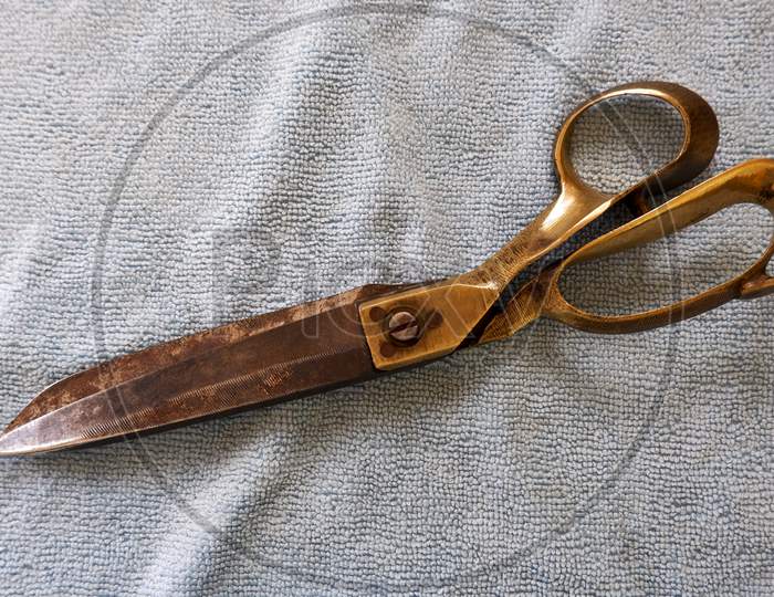Top View Of Old Tailor Scissor Isolated On Cloth Background