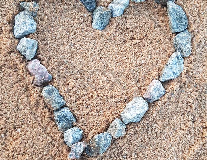 heart shaped stones on sand Background