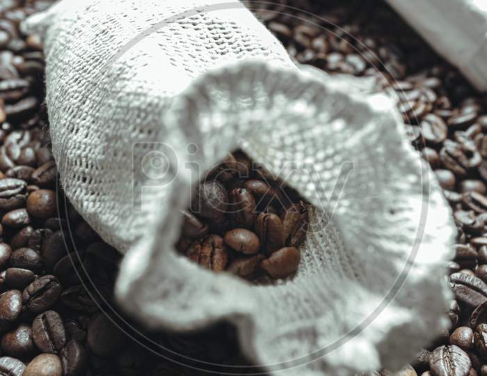 A Close Up Of A Coat Filled And Surrounded By Coffee Grains