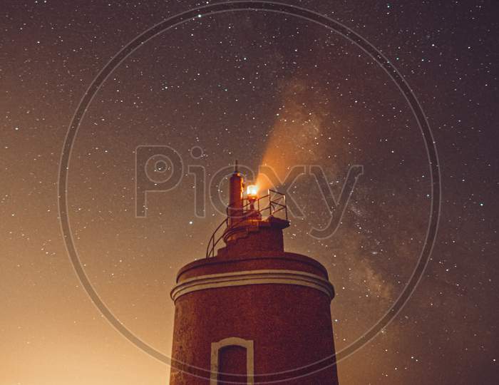 Lighthouse During The Night With The Sky With A Lot Of Stars