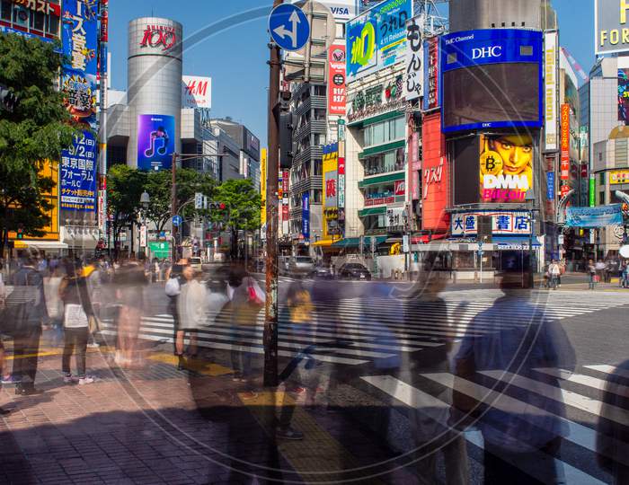 Blurred People In Motion Crossing The Famous Shibuya Intersection In Tokyo Japan