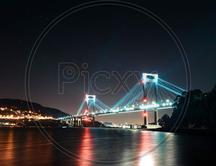 A Super Panoramic View Of A Full Of Lights Bridge During Night