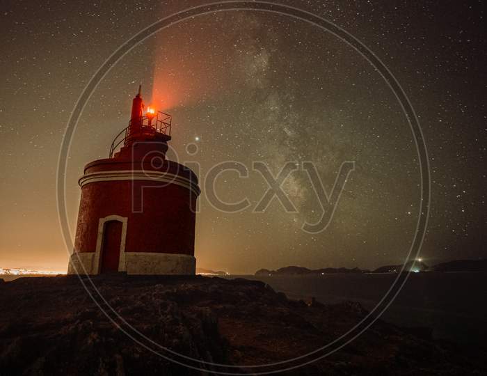 An Horizontal Shot Of A Lighthouse During The Night With The Sky With A Lot Of Stars