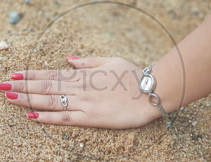 Female hand five fingers isolated on sand background