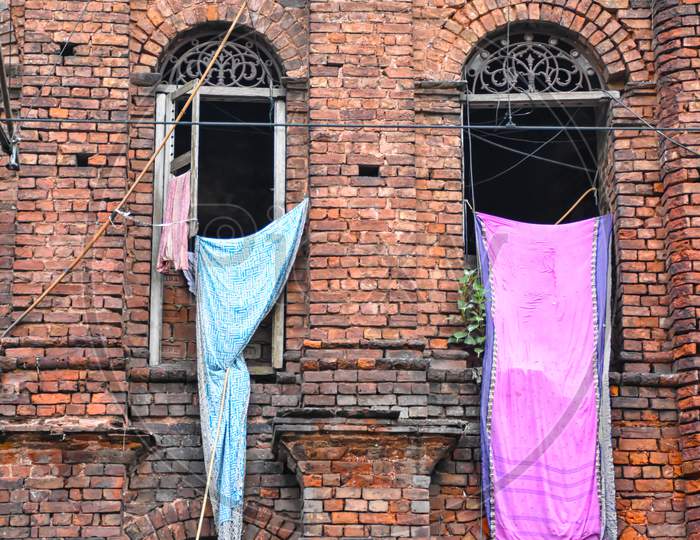 Clothes Are Hanging From The Windows Of A Red Brick Wall Vintage Building