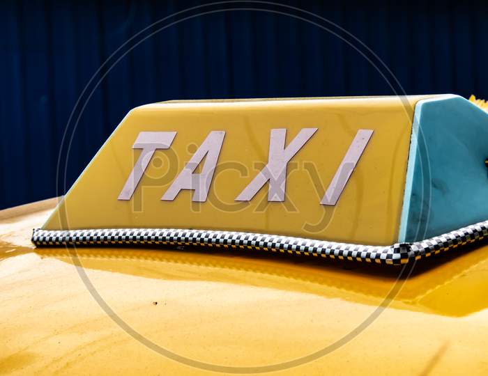 A Close Up Sign Of Taxi On The Yellow Car Famous In Kolkata.