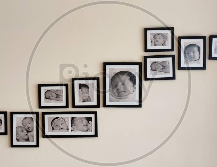 Photo frames on wall having pictures of babies