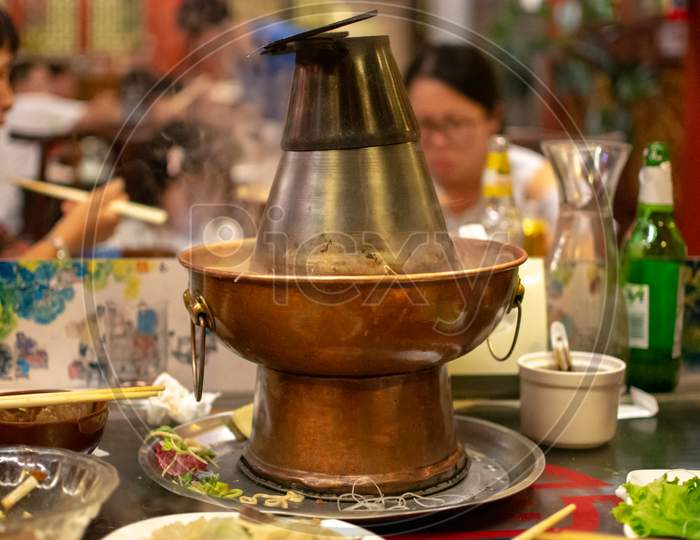 Traditional Beijing Style Chinese Coal-Heated Brass Hot Pot In A Restaurant