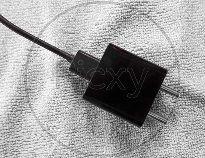 Electrical Mobile Adapter Plug Isolated On Cloth In Black & White