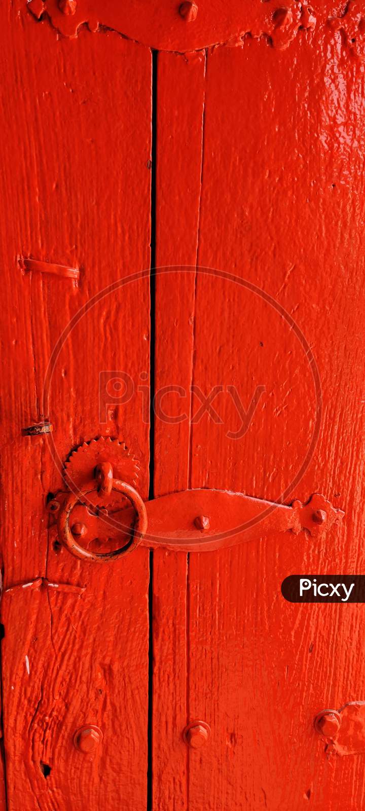 An old metal door handle knocker on a wooden door