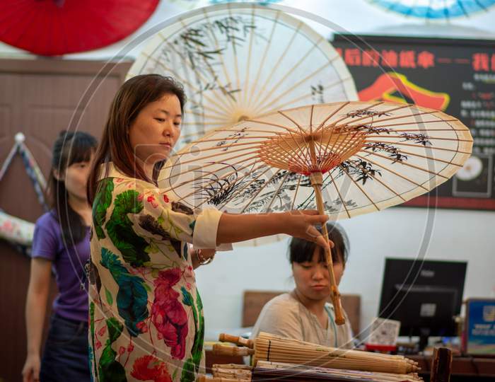 Chinese Woman Holding Decorated Chinese Oilpaper Umbrella In Beijing, China