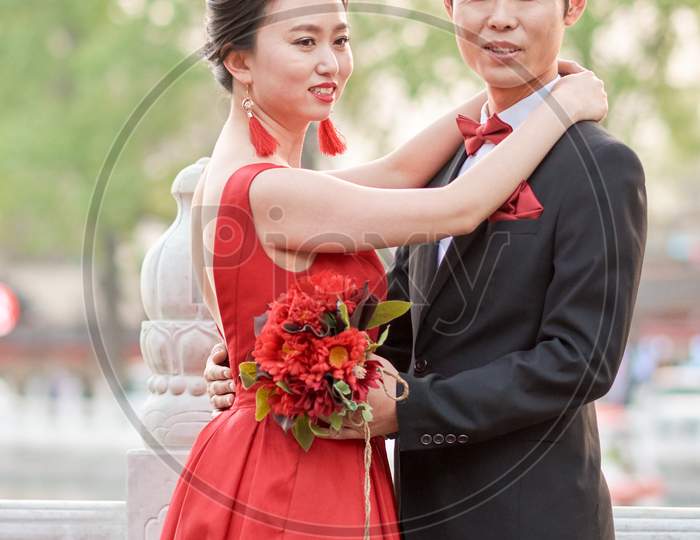 Cute Chinese Wedding Couple Posing Outdoors In Houhai Lake Park, Beijing, China