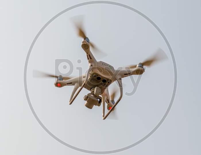 Modern Rc Drone / Quadcopter With Camera Flying In A Bright And Clear Blue Sky. New Technology In The Aero Photo Shooting.