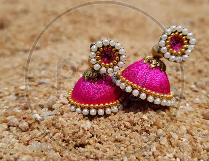 Holding Hand made colorful Earrings with blurred background