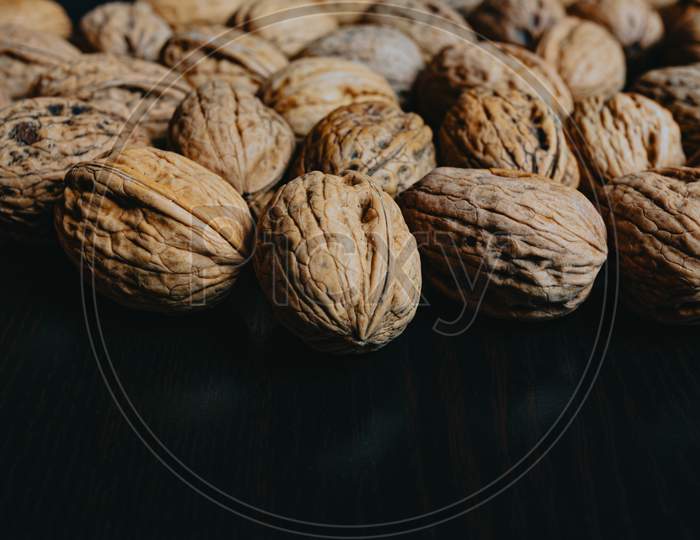Close Up Of Some Nuts Over A Dark Background