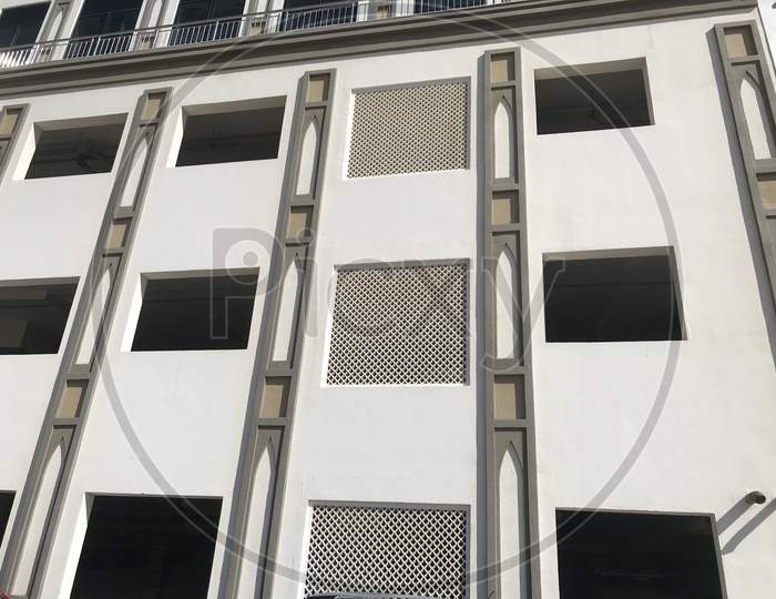 An Elevated Car Parking Of High Rise Building With Aluminum Windows Framed With Black Tinted Sun Protection Film For The Privacy Purposes