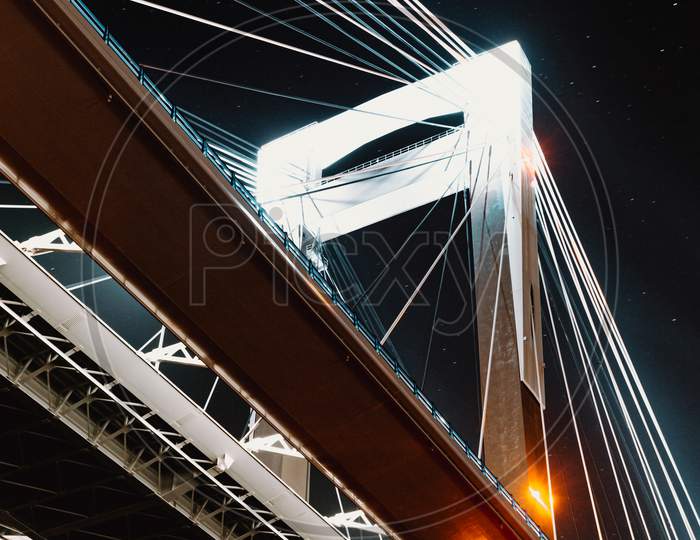 A Close Up Of One Column Of A Bridge During The Night
