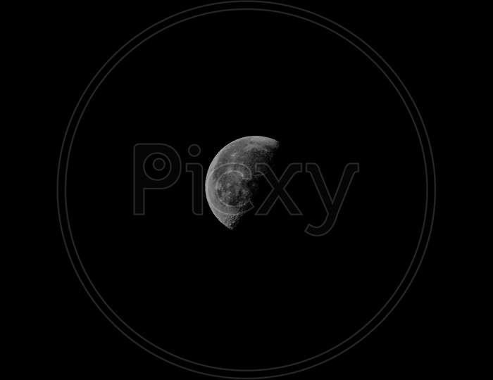 A Close Up Of A Dark Grey Moon Over A Full Black Background
