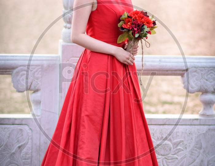 Pretty Chinese Bride In Red Dress Posing Outdoors In Houhai Lake Park In Beijing
