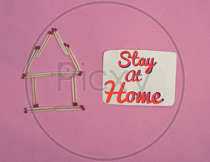 Stay At Home Conceptual Photo With Match Stick Made House Isolated On Pink Background