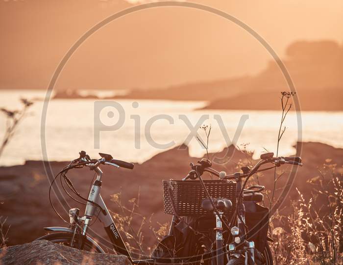 Two Vintage Bikes On The Beach During The Sunset