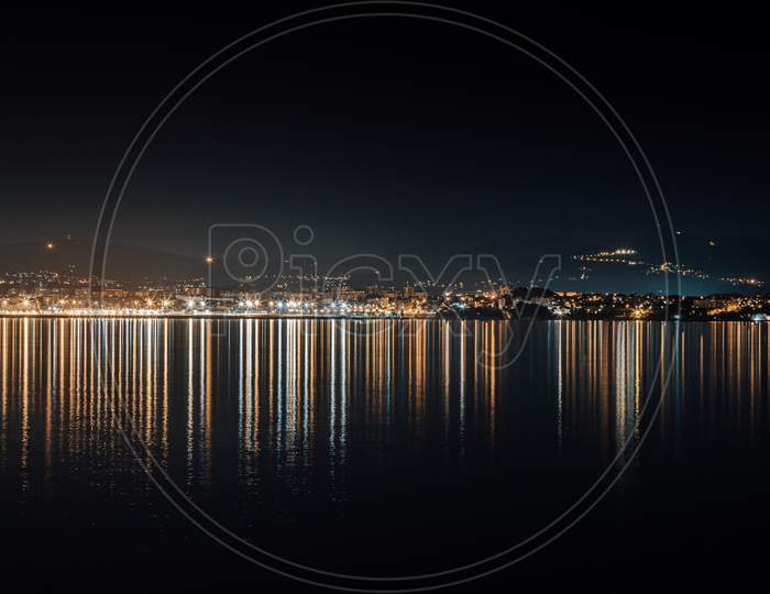 City Skyline Lights Reflecting In The Sea During The Night