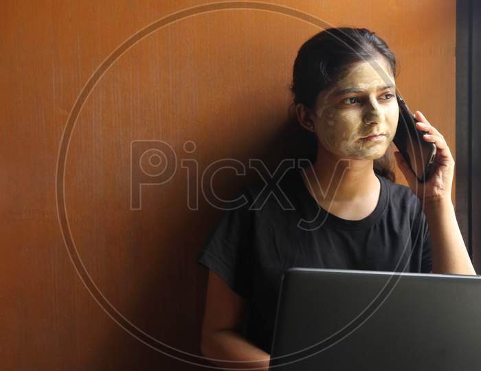 women working on laptop and applying face pack