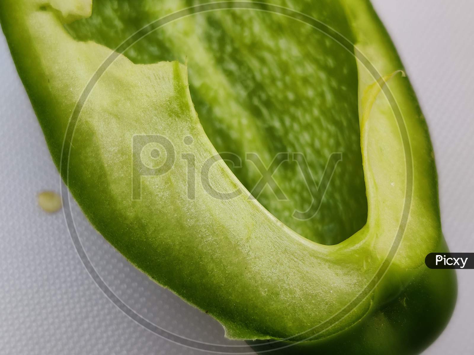 slice of green bell pepper or capsicum isolated on white background