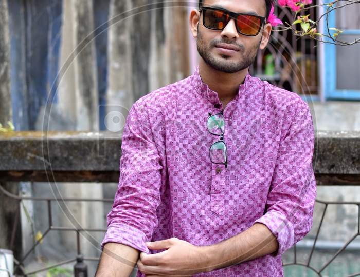 Portrait Of A Young And Handsome Indian Bengali Man Standing In Front Of A Vintage House Wearing Green Indian Traditional Punjabi. Indian Lifestyle And Fashion.