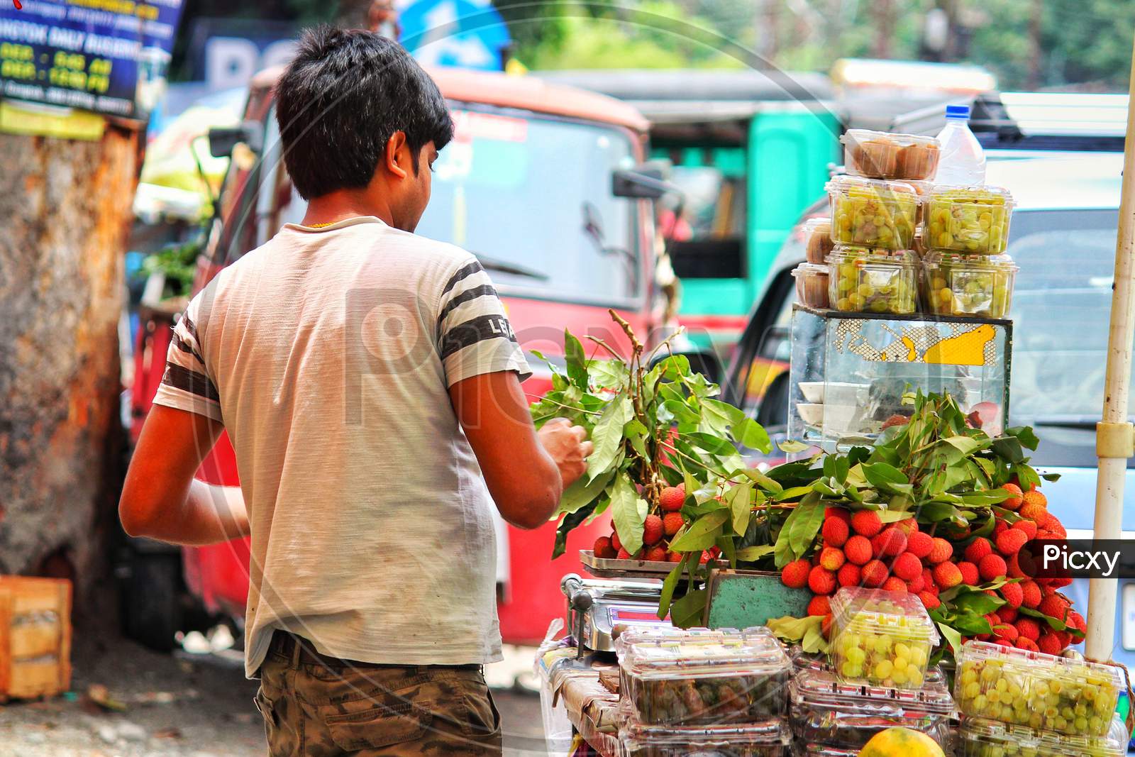 A Local Fruit Vendor Selling Fruits On Street .