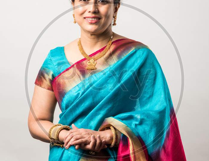 Portrait Of Mid Age Or Old Indian Asian Woman Or Lady In Traditional Saree Against White Background