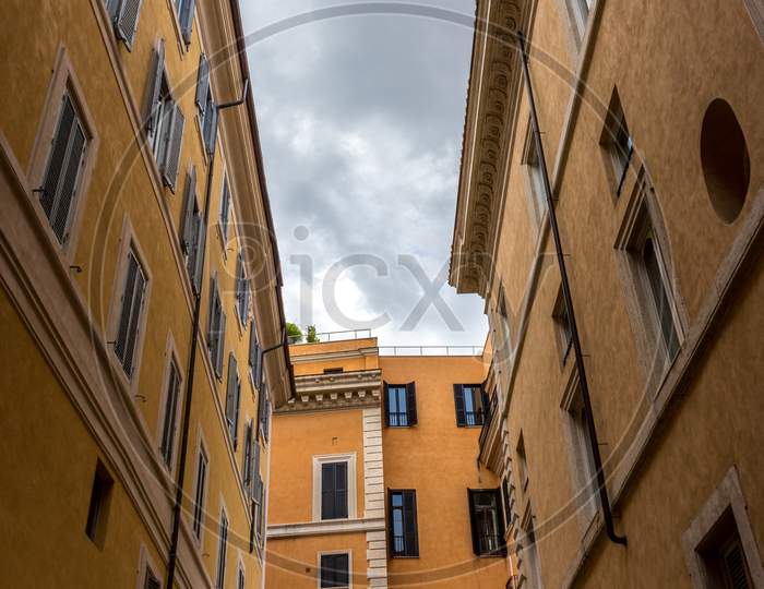 Rome, Italy - 23 June 2018: A Narrow City Street With Buildings On The Side Of A Building In Rome, Italy