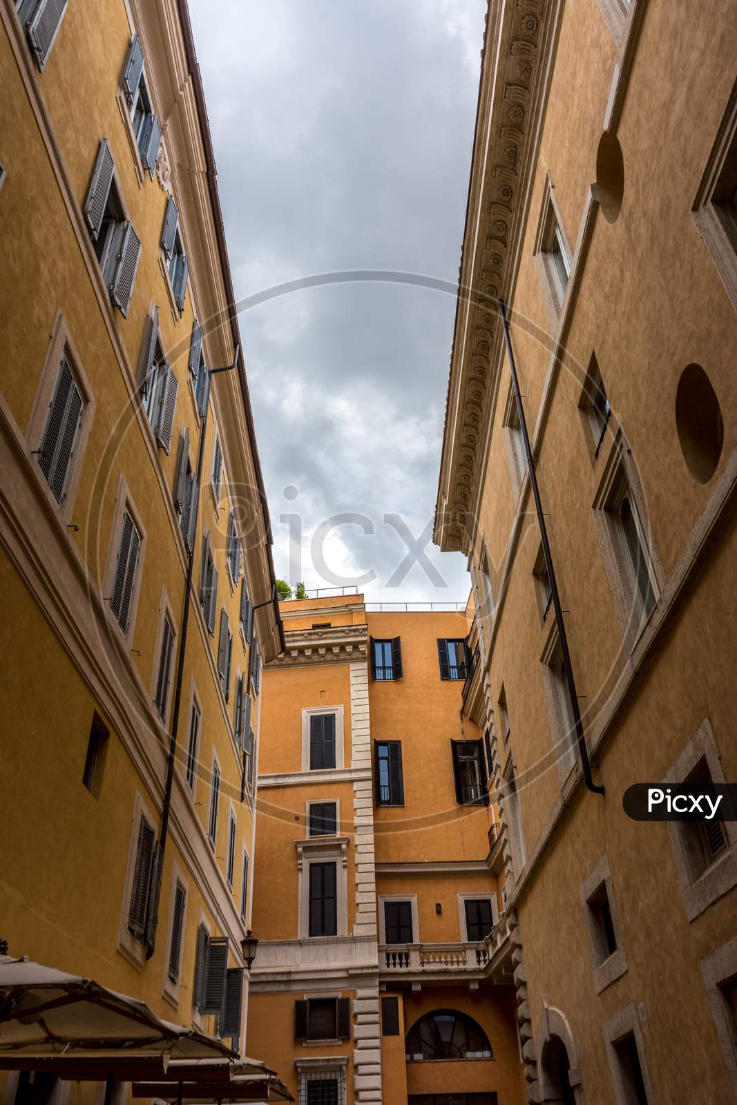 Rome, Italy - 23 June 2018: A Narrow City Street With Buildings On The Side Of A Building In Rome, Italy