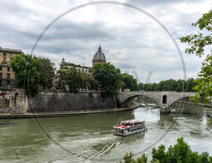 Rome, Italy - 23 June 2018: Boat Floating Adjacent To A Bridge On The Tiber River In Rome, Italy