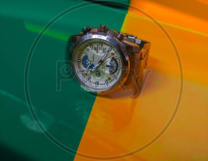 Chronograph white dial wrist watch orange green background