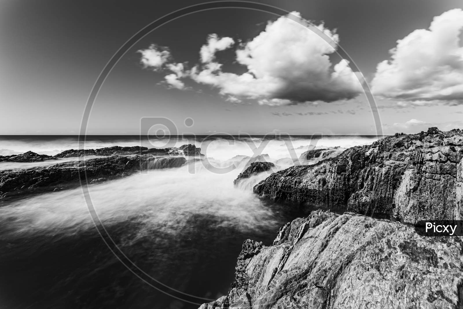 Dramatic Black And White Long Exposure Shot Of The Rocky Coast In Spain During A Bright And Cloudy Day