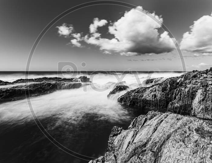 Dramatic Black And White Long Exposure Shot Of The Rocky Coast In Spain During A Bright And Cloudy Day