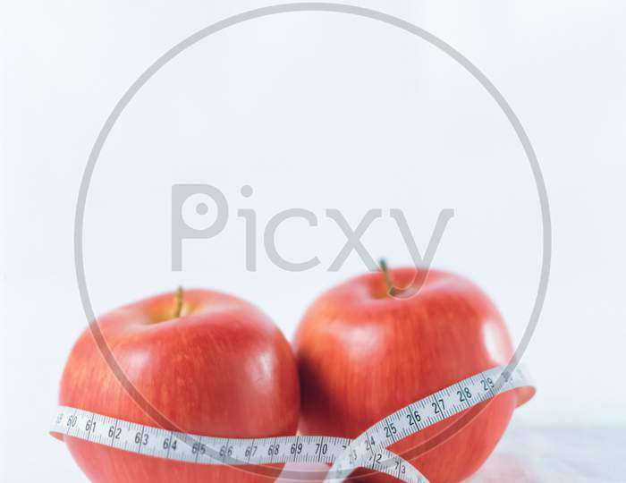 Apples and measurement tape with blurred background